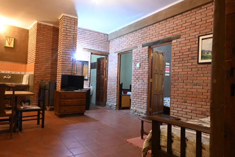 Ambiente principal de la Cabaña 2 con televisor y acceso a los dormitorios
