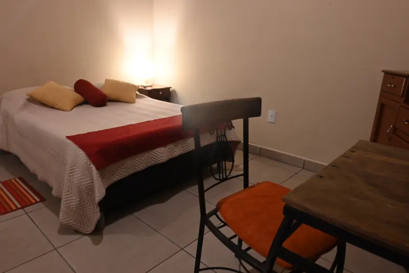 Mesa y silla junto a la cama en la Cabaña 6
