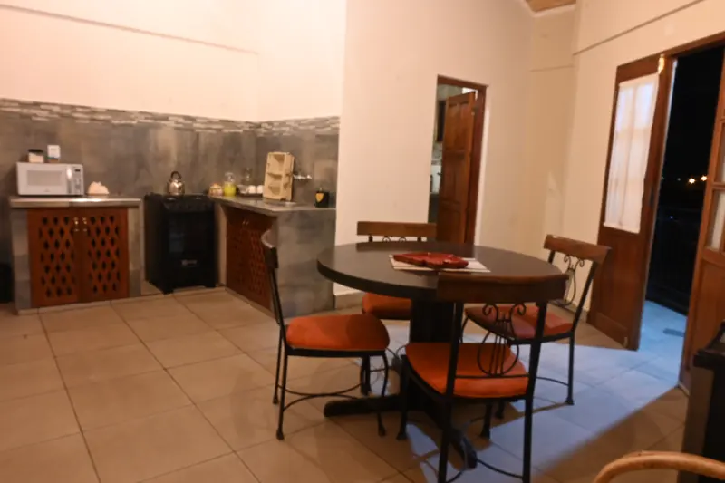Cocina y mesa redonda de la Cabaña 7, con puerta al balcón