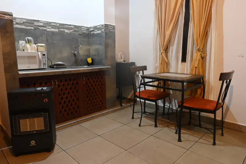 Kitchenette, mesa con dos sillas y estufa en la Cabaña 8