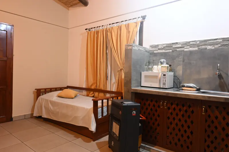 Sofá cama de madera junto a la kitchenette en la Cabaña 8