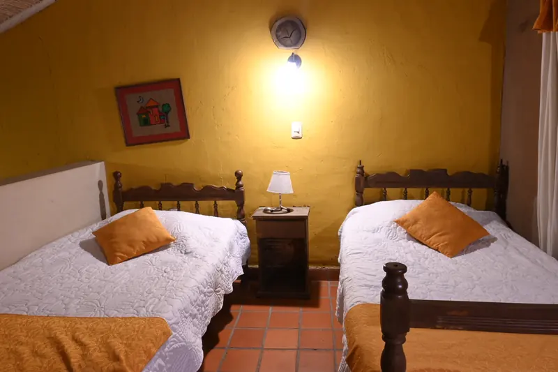 Dos camas simples con mesa de noche en la Cabaña 9