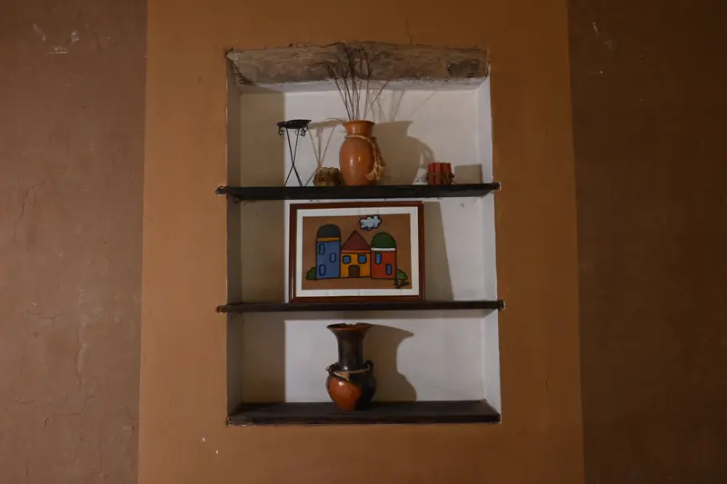 Nicho con cerámicas y un cuadro en la pared de la Cabaña 9