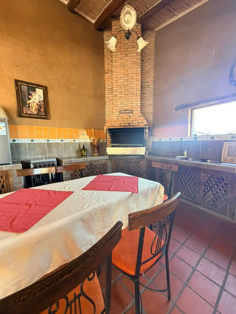 Parrilla y cocina del quincho, con una ventana hacia los cerros